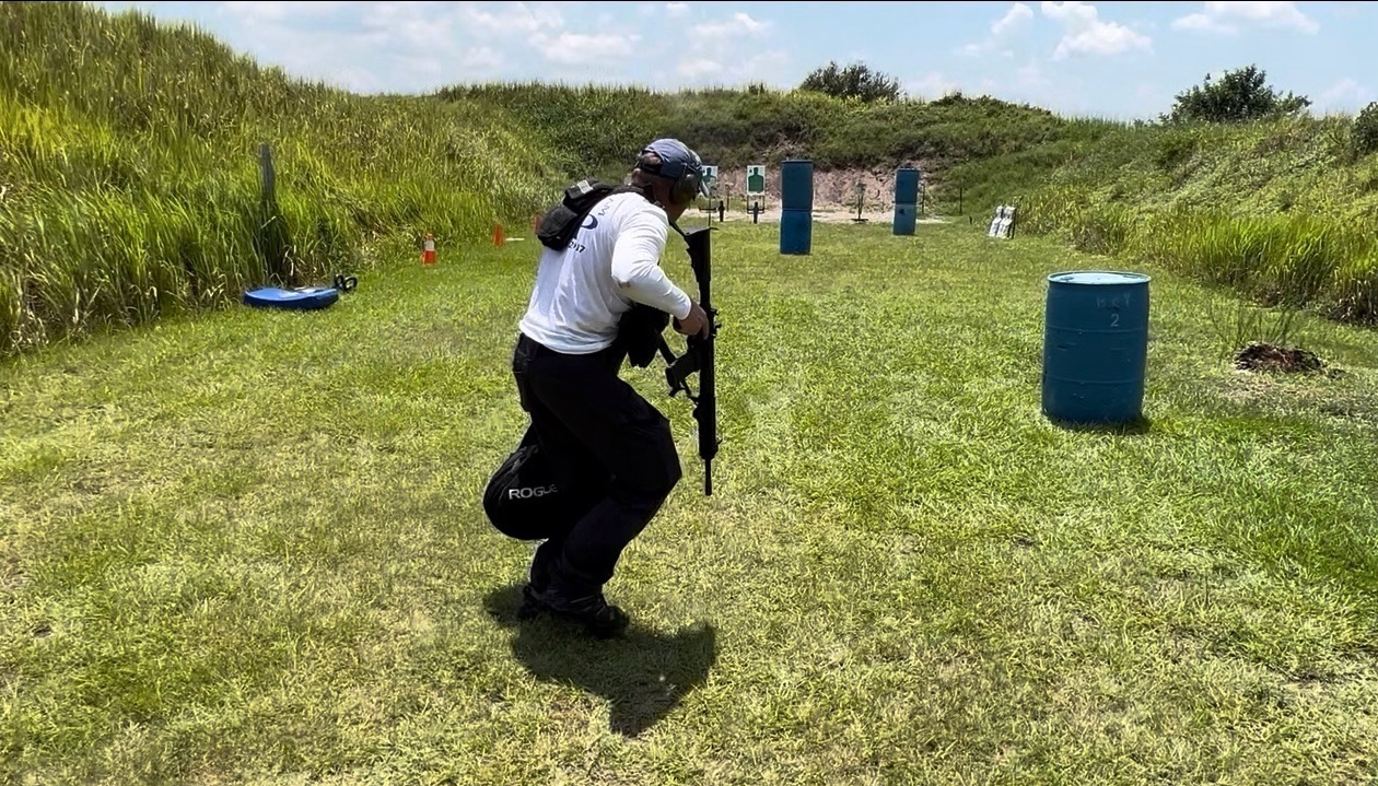 Shooter moving between barrels during a stress-run carbine drill